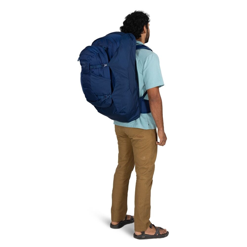 Person wearing a large blue backpack on a white background