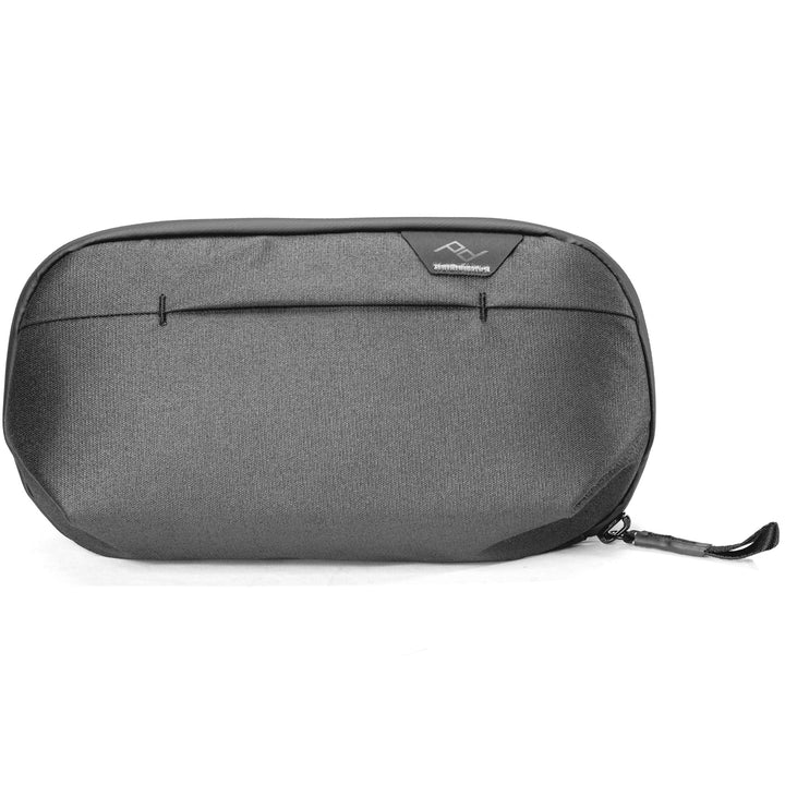A dark gray textured zippered pouch with a small black logo patch on the front, photographed on a clean white background.