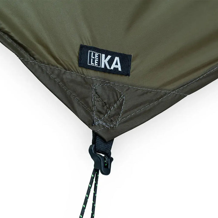 Corner of a green tarp with guy line attached to corner and LELEKA branding 