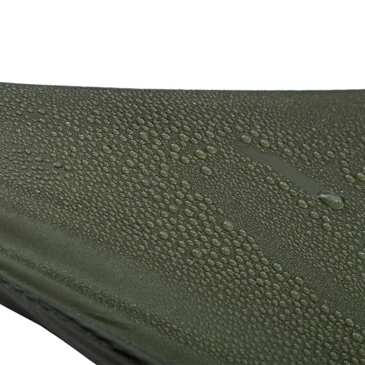 Close-up of an olive green waterproof fabric surface covered with water droplets on a white background.