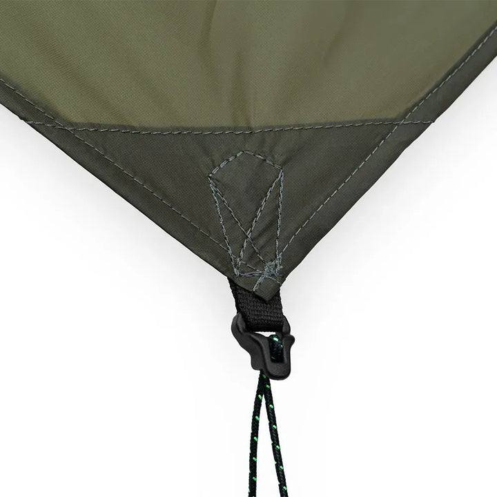 Close-up of an olive green tent or tarp corner with dark gray stitching, a black plastic hook-and-loop fastener, and a black-and-green drawcord on a white background.