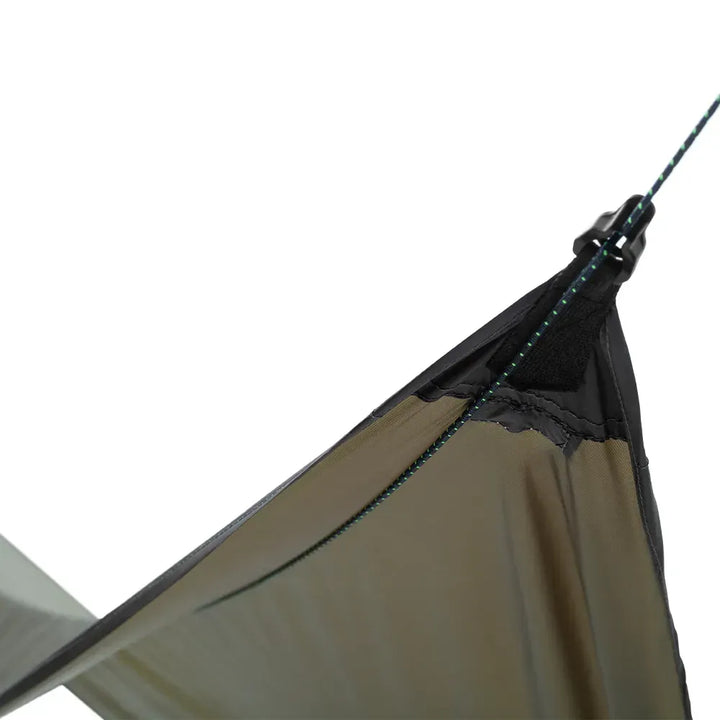 Close up of an olive green tarp with black details attached to a black and green guy-line on a white background. 