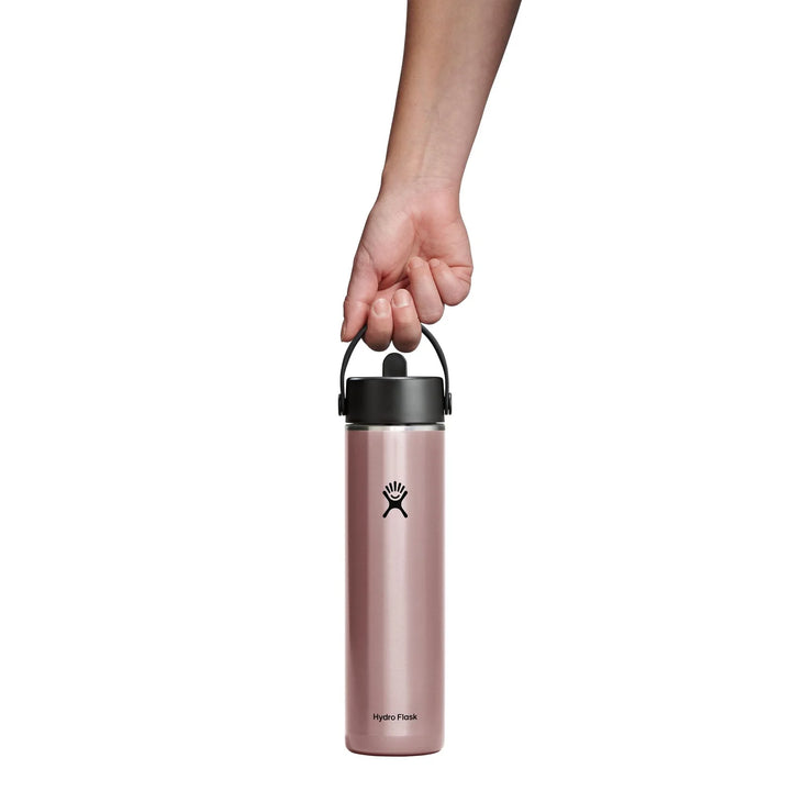 Pink Hydro Flask water bottle held by a hand on a white background