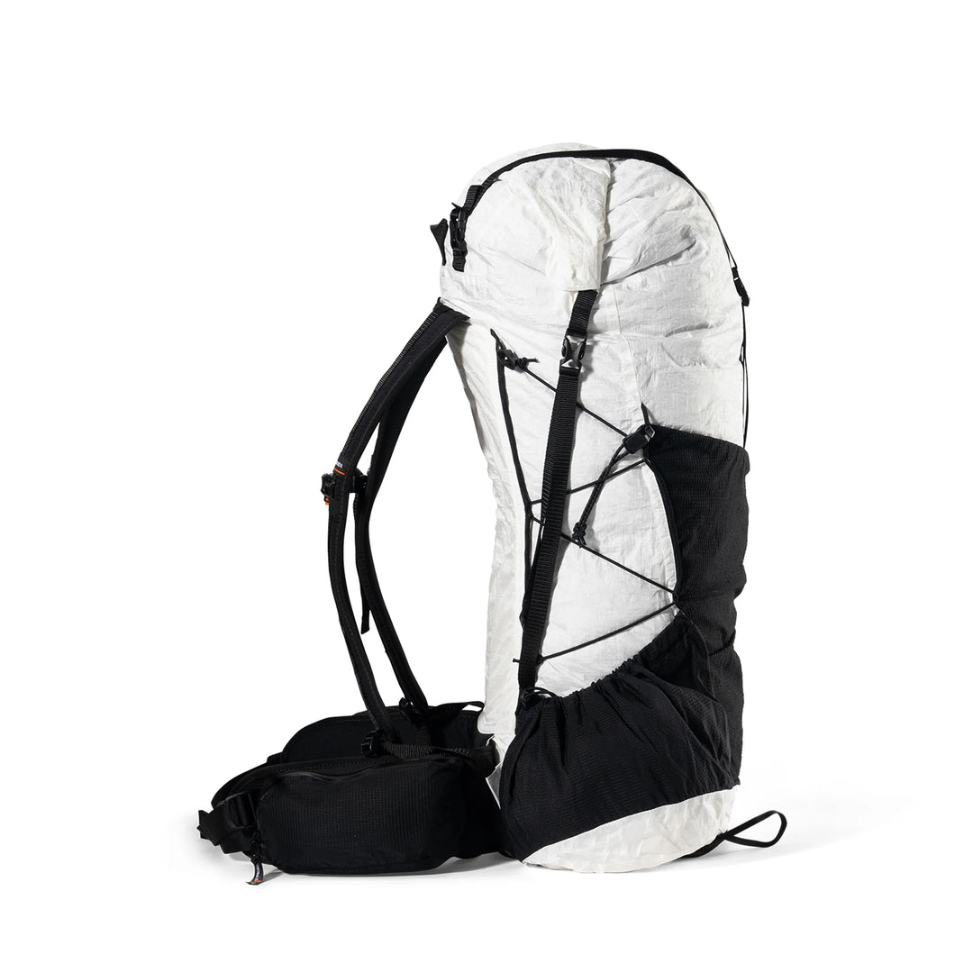 A technical outdoor backpack shown from the side against a plain white background. The backpack features a white upper body with black compression straps and a black lower compartment and shoulder straps.
