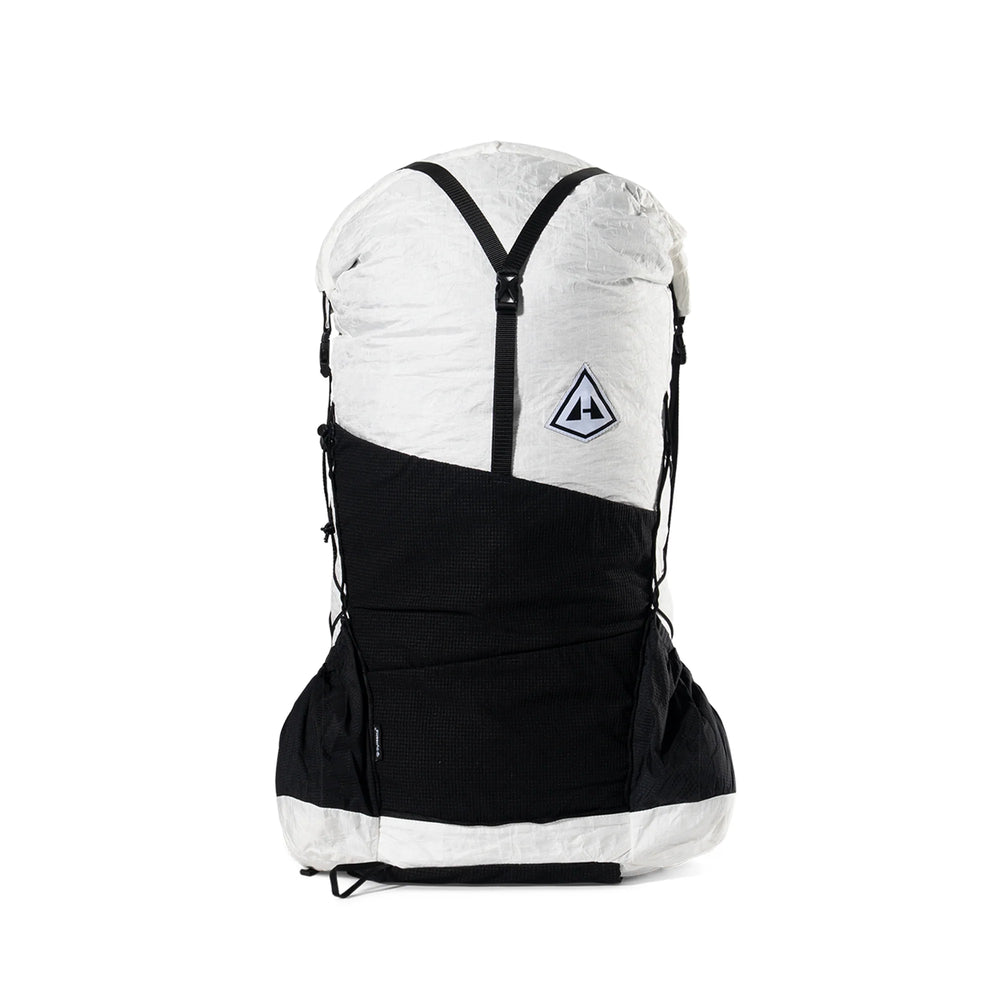 A dual-color backpack in white and black, featuring a white top section with a black Y-shaped zipper, a black lower body, and a small triangular logo patch on the front.