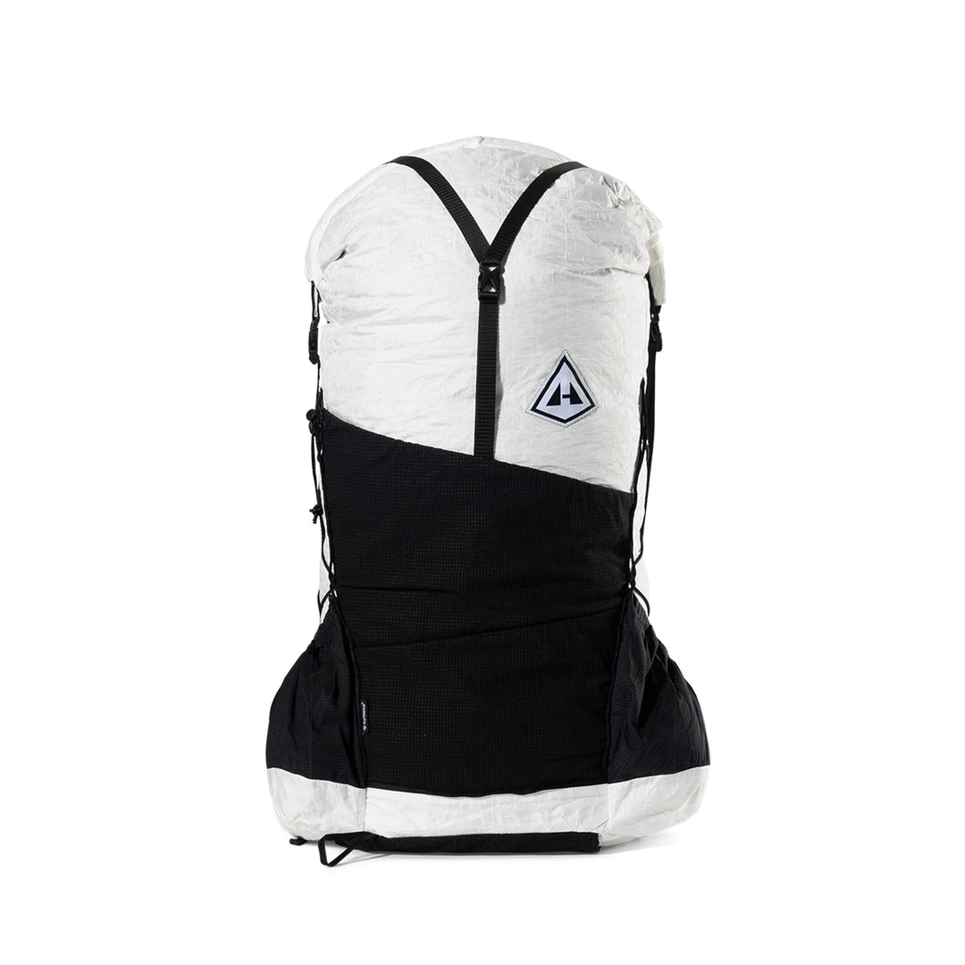 A dual-color backpack in white and black, featuring a white top section with a black Y-shaped zipper, a black lower body, and a small triangular logo patch on the front.