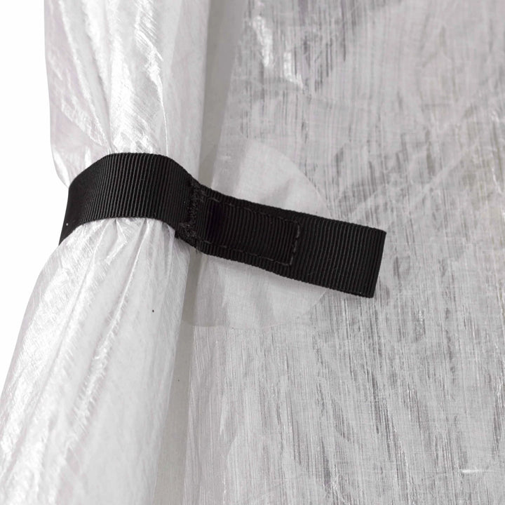 Black strap securing a clear tent against a light gray background