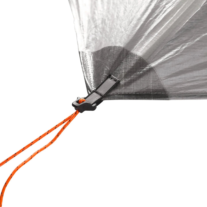 Close-up of a Dyneema tent with an orange cord and black clip on a white background