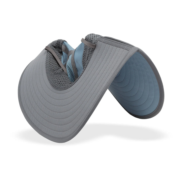 Gray and blue visor hat turned upside down and bent in half to show flexibility on a white background