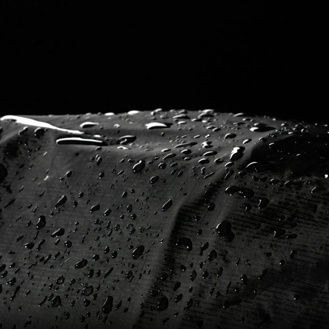 Close-up of water droplets on a textured surface with a black background
