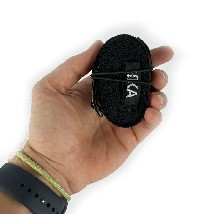 Hand holding a black rolled up strap with a brand logo on a white background