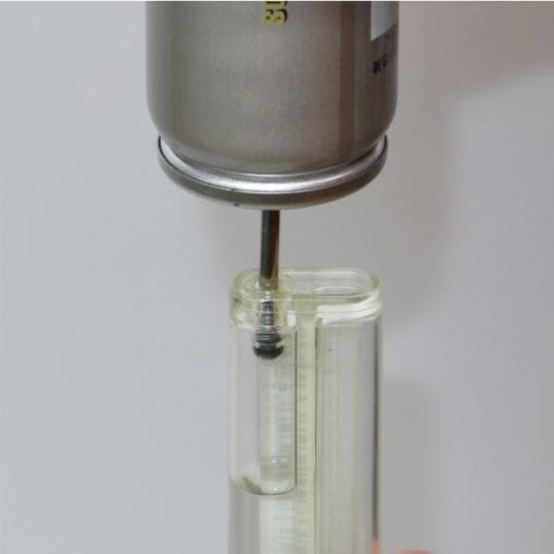 Fuel canister going into a clear lighter to refill it. 