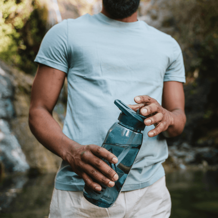 Person holding a water bottle in the outdoors