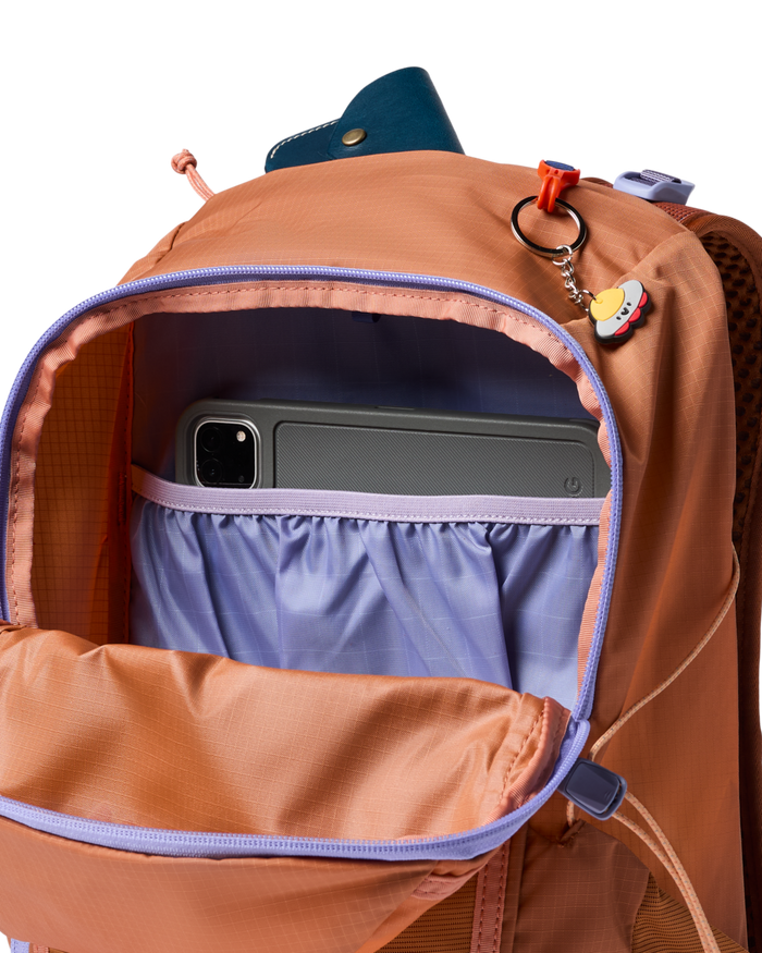 Open orange backpack with a purple inside on a white background