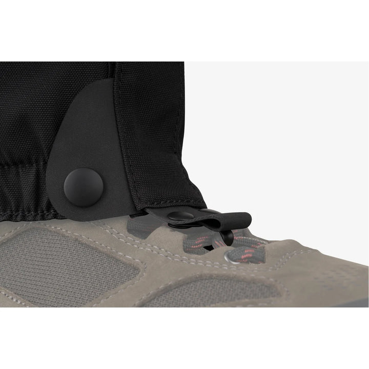 Close-up of a shoe with a black gaiter on a white background