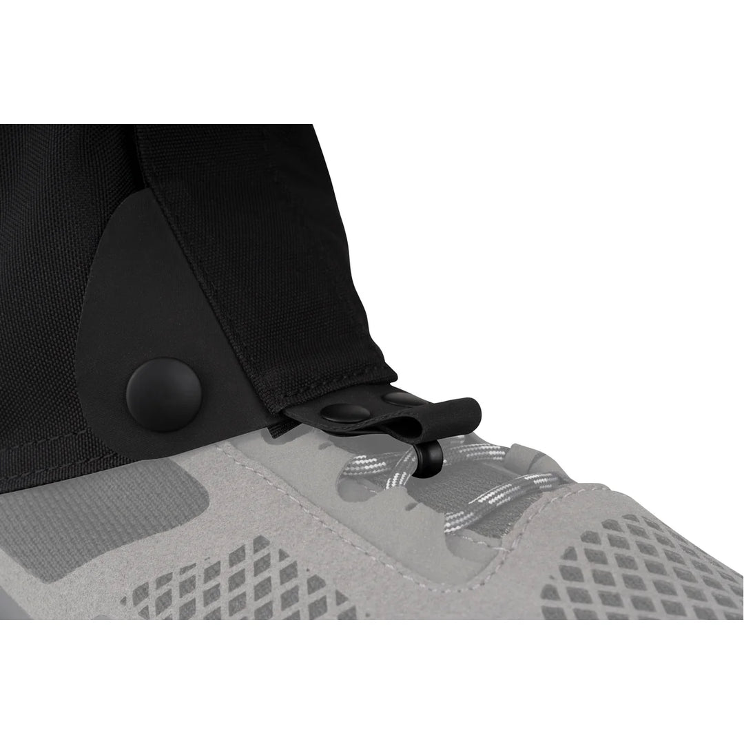 Close-up of a black gaiter attached to a gray shoe on a white background