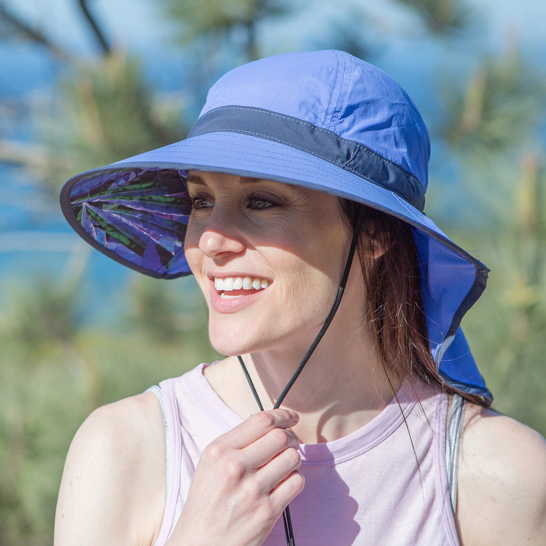 Woman wearing a blue sun hat with a visor, outdoors.