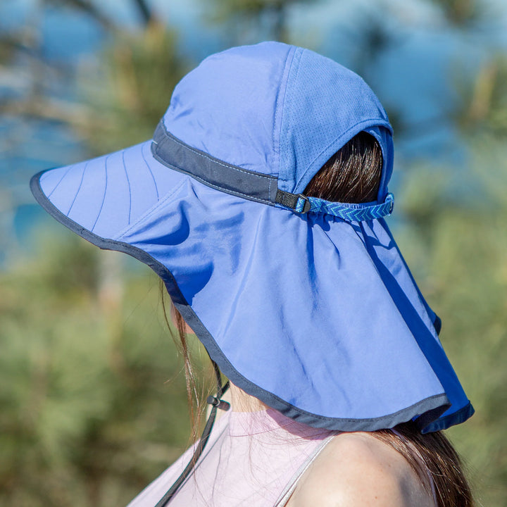 Person wearing a blue sun hat with neck flap outdoors