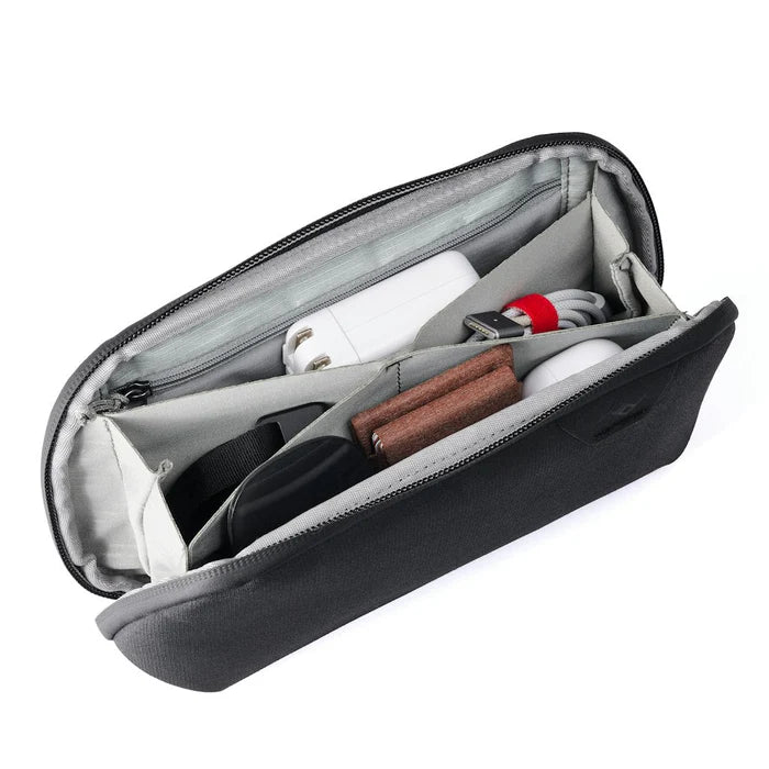 Inside of dark grey accessory pouch with light grey interior and different pockets for organization on a white background