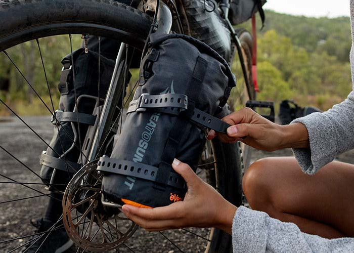 Person mounting a ten bag on the fork of a bicycle