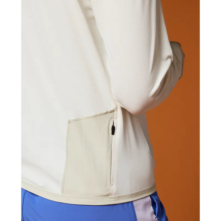 Close-up of a person wearing a white shirt with a pocket on an orange background