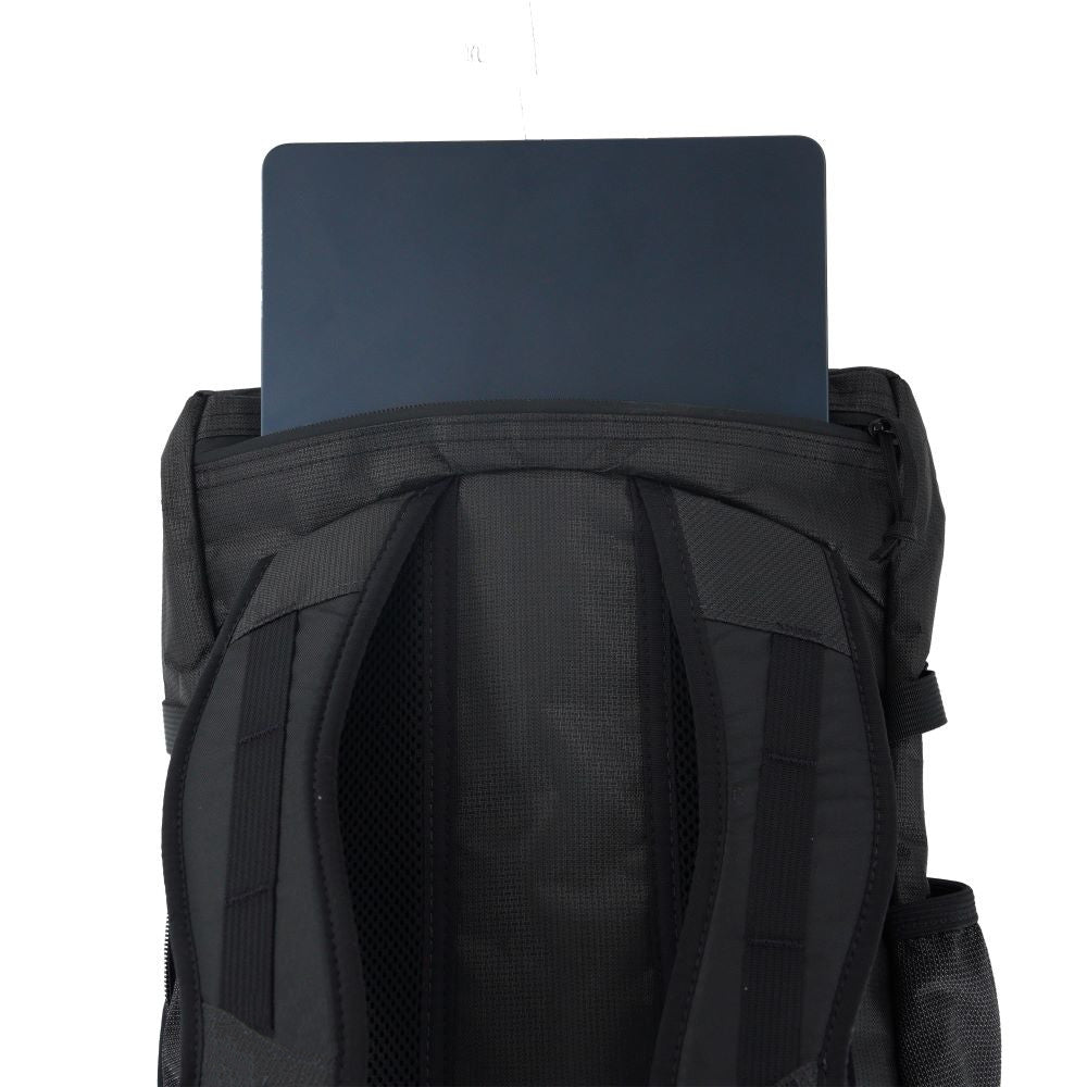 Black backpack with a laptop placed on top against a white background