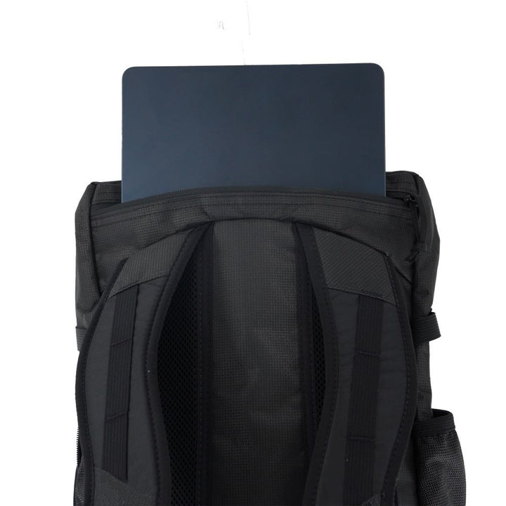Black backpack with a laptop placed on top against a white background