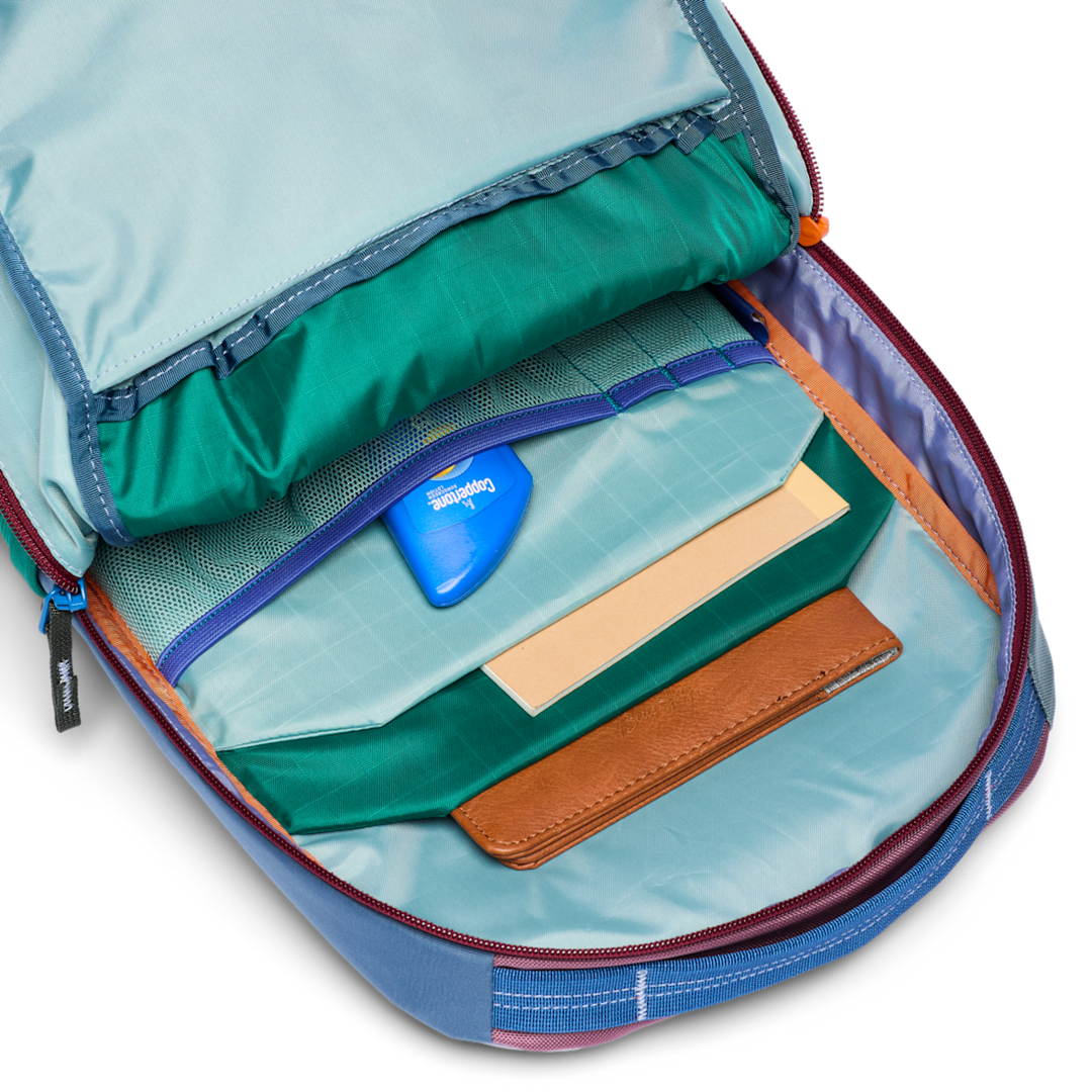 Open backpack with compartments and a blue tag on a white background