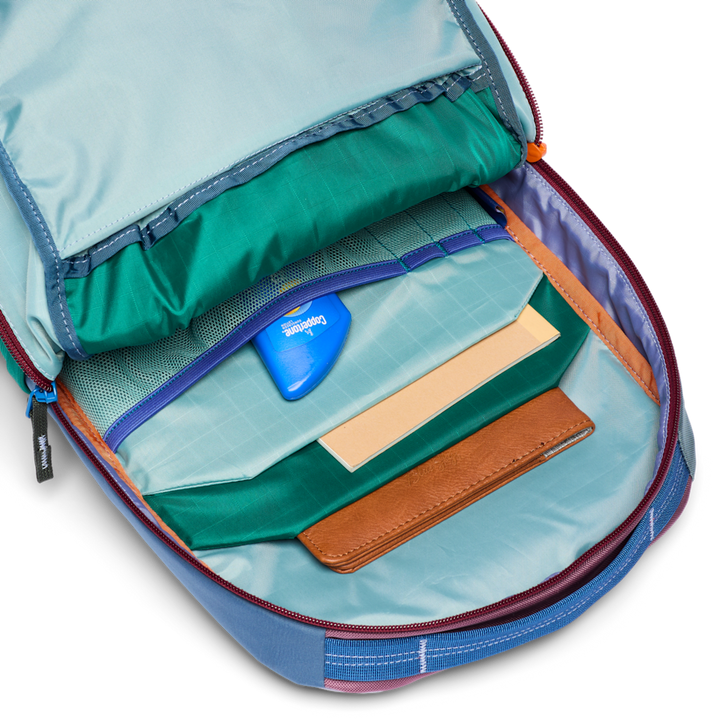Open backpack with compartments and a blue tag on a white background