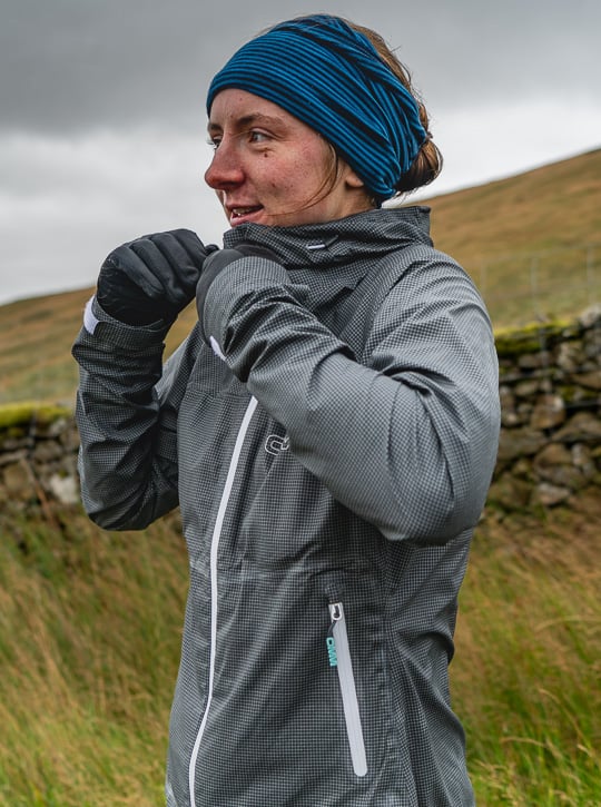 Person wearing a gray jacket and blue beanie in a natural setting